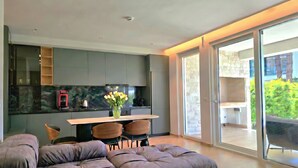 Een moderne keuken met een eethoek, een bank en een schuifdeur naar een balkon.