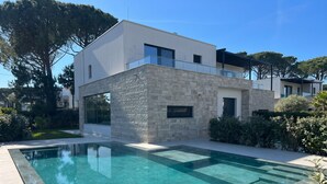 A modern two-story house with a swimming pool in the foreground. - Superb Villa With Pool in San Pietro Resort (Gjiri Lalzit)