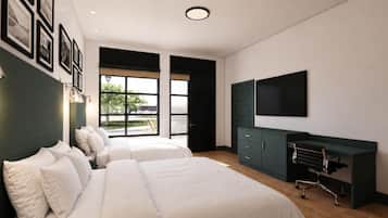 A modern bedroom with two beds, a desk, a chair, a TV, and a large window.