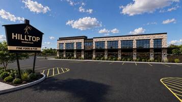 A modern building with a sign for Hilltop Skaneateles Fine Food & Fun.