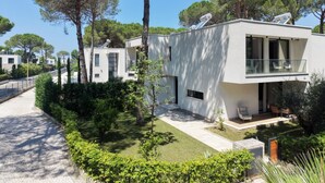 A modern two-story building with a flat roof, satellite dish, and a small patio area. - Seaside Premium Villa (Gjiri Lalzit)