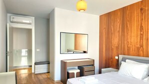 A hotel room with a bed, bedside tables, a mirror, a wardrobe, and a bathroom with a shower. - Seaside Premium Villa (Gjiri Lalzit)