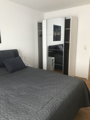 Ein Schlafzimmer mit einem Bett, einem Kleiderschrank und einem kleinen Tisch.
