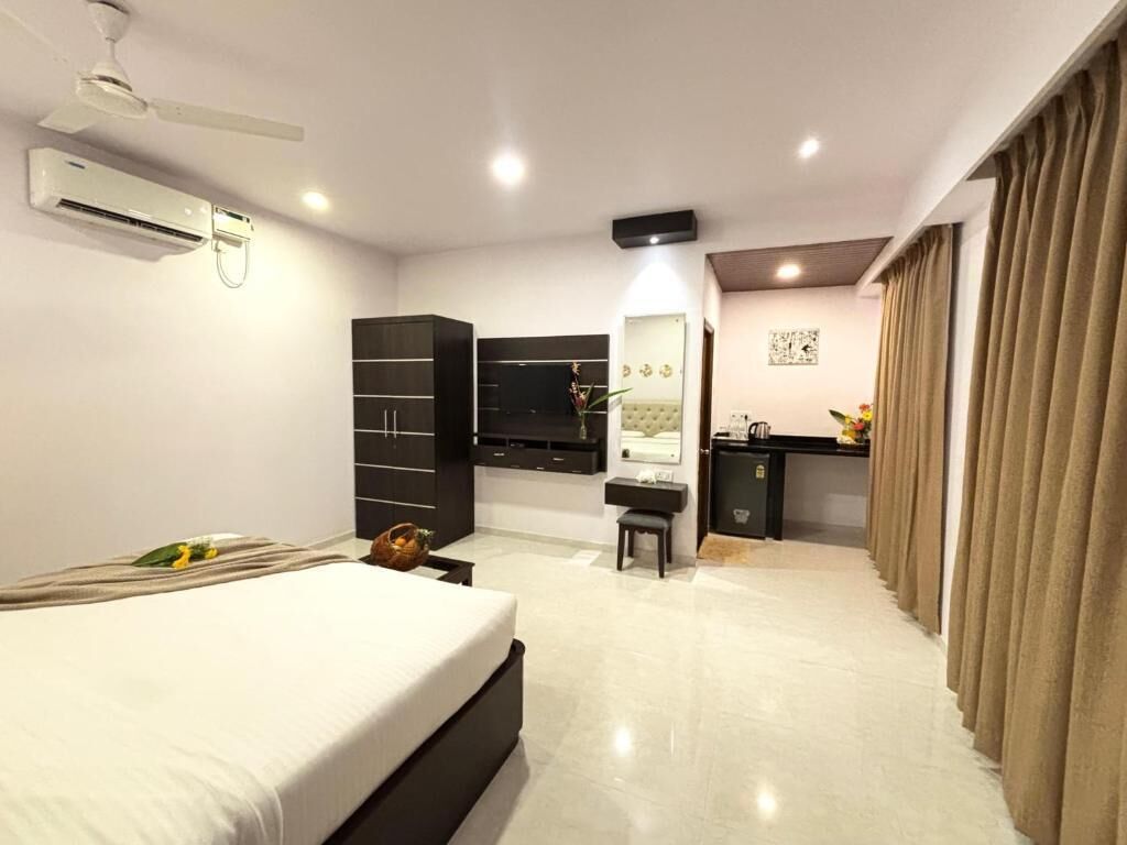 Een hotelkamer met een bed, een bureau, een kledingkast en een kitchenette.