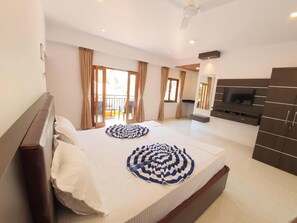 A hotel room with a bed, a TV, a balcony, and a view of the outdoors. - Casa de Laura (Calangute)