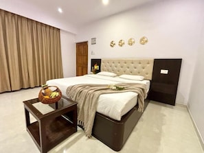 Un dormitorio con cama, mesita de noche, lámpara de pared y una puerta.