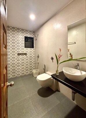 Un baño con inodoro, lavabo, espejo y un ventanal pequeño.