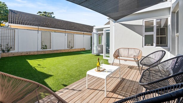 A patio with a table, chairs, and a bottle of wine. - Sangrove Residence (Cape Town)