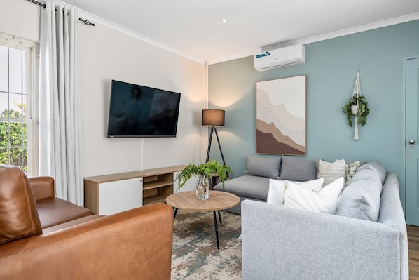 A modern living room with a sofa, armchair, and a coffee table.