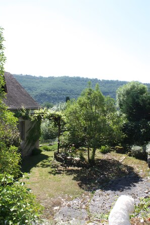 A rustic house with a garden, a small pond, and a dog. - Le Jardin aux Lilas – Private Pool, Renovated House in Lot Valley (Cadrieu)