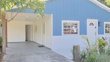 A blue building with a covered entrance, a door, and a window.