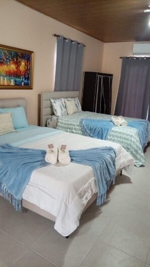 A hotel room with two beds, a painting on the wall, and a window with curtains. - Brisas del Mar (Veracruz)