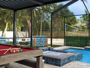 Ein Poolbereich mit Billardtisch, Kinderspielplatz und Whirlpool.