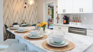 A modern kitchen with white cabinets, a marble countertop, and a coffee bar area. - Stay & Play Downtown Tampa Sleeps 10- HotTub & Bar (tampa)