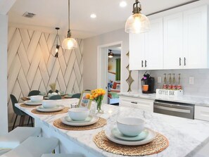 A modern kitchen with white cabinets, a marble countertop, and a coffee bar area. - Stay & Play Downtown Tampa Sleeps 10- HotTub & Bar (tampa)