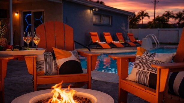 A poolside area with lounge chairs, a fire pit, and a pool. - Tampa High Roller, Relax and Play (Tampa)