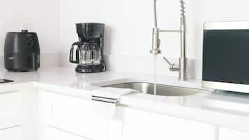 Eine moderne Küche mit Kaffeemaschine, Wasserkocher und Spüle.