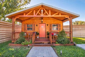 Eine Holzhütte mit Veranda, Tür und kleinem Garten.