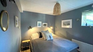 A bedroom with a bed, bedside tables, wall-mounted lamps, framed pictures, and a window with a view. - 5 Star Holiday Home in Uddevalla (Uddevalla)