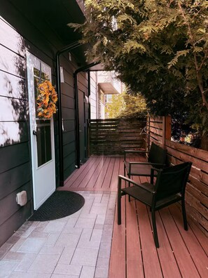 A wooden deck with a bench and a door with a wreath. - The May Townhome - Lower (Seattle)