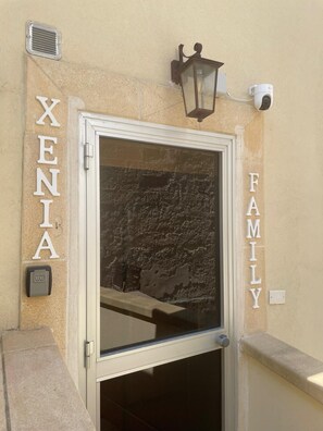 Una puerta con la inscripción 'XENIA FAMILY' en la pared de al lado.