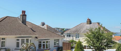 Un quartier résidentiel avec des maisons, un jardin et un ciel dégagé.