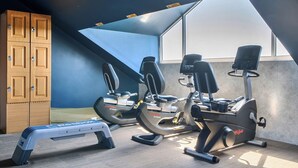 A gym with exercise equipment, a step platform, and a wooden cabinet. - Cotswolds Apartment 4, Sleeps 9 (Chipping Norton)