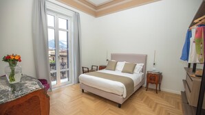 A bedroom with a bed, a desk, a chair, a dresser, and a window with a view. - Luxury Boutique Apartment 1 in Palermo City Center, near the Central Station (Palermo)