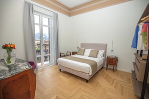Ein Schlafzimmer mit Bett, Schreibtisch, Stuhl, Kommode und Fenster mit Blick.