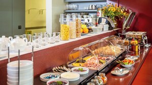 A buffet setup with various food items, glassware, and serving utensils.