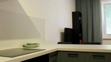Une cuisine avec un plan de travail, un saladier, un appareil électroménager noir et des placards.