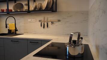 A modern kitchen with a black countertop, a built-in stove, and a sink.