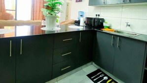 Uma cozinha moderna com armários escuros, uma ilha central e uma área de jantar com vista.