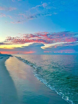 A coastal landscape with a beach, ocean, and a distant bridge. - Cozy Beach Front Retreat (Pensacola Beach)