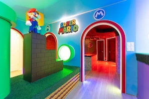 A Super Mario themed room with a Mario statue, a sign, and a red-lit archway. - Orlando Most Incredible Themed 10br Villa (Clermont)
