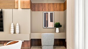 Un intérieur moderne avec un canapé, une petite table, une plante en pot et une œuvre d’art encadrée accrochée au mur.