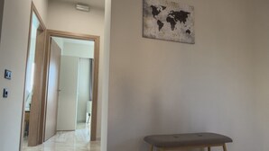 A hallway with a bench, a world map artwork, and a door leading to another room. - Eligio Luxury Residence with Private Jacuzzi & Sea View (Gournes Gouvon)