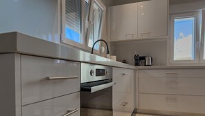 A modern kitchen with built-in appliances, a window, and a view of the sky. - Eligio Luxury Residence with Private Jacuzzi & Sea View (Gournes Gouvon)