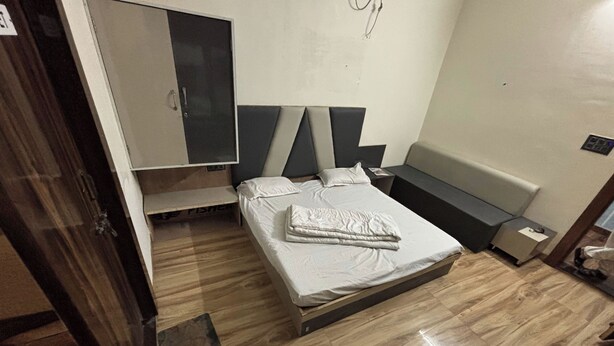 A bedroom with a bed, a wardrobe, and a bench. - MANAN PALACE HOTEL (Mungaoli)