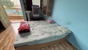 A small room with a bed, a sink, and a window. - MANAN PALACE HOTEL (Mungaoli)