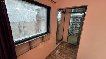 Un pasillo con ventanal, suelo de madera y pared de baldosas.