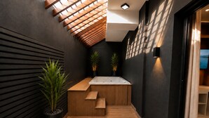 A modern bathroom with a wooden bench, a large bathtub, and two potted plants. - Modern 1BR Retreat with Private Jacuzzi & Patio up to, 4 guests allowed. (Santiago De Los Caballeros)