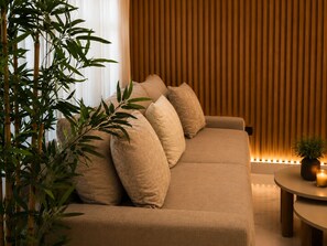 A modern living room with a sofa, cushions, a round coffee table, and a potted plant. - Modern 1BR Retreat with Private Jacuzzi & Patio up to, 4 guests allowed. (Santiago De Los Caballeros)