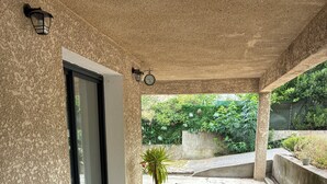 A round table with four chairs, a potted plant, and a wall-mounted clock. - TO THE SOUND OF BIRDSONG House in Provence with private garden and parking (Les Pennes-Mirabeau)