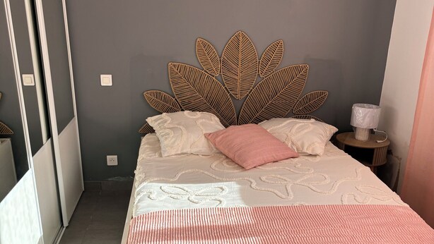 A bedroom with a bed, pillows, a nightstand, and a wall-mounted lamp. - TO THE SOUND OF BIRDSONG House in Provence with private garden and parking (Les Pennes-Mirabeau)