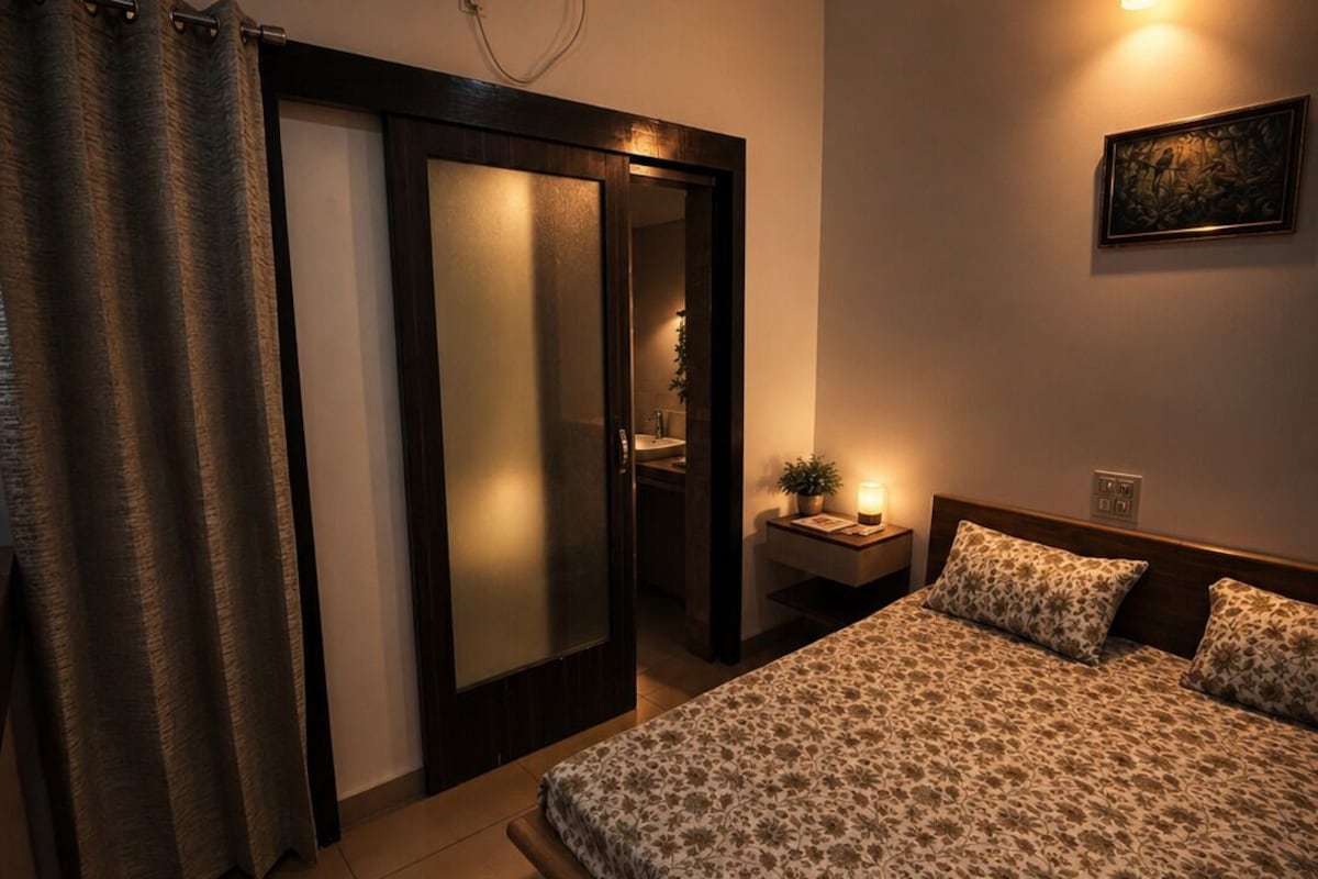 Ein Schlafzimmer mit einem Bett, einem Nachttisch, einer Wandlampe und einer Klimaanlage.