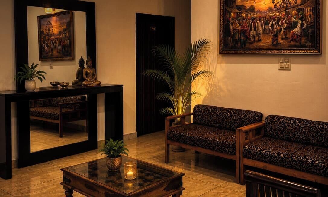 A room with a sofa, a table with a candle, a mirror, and a painting on the wall.