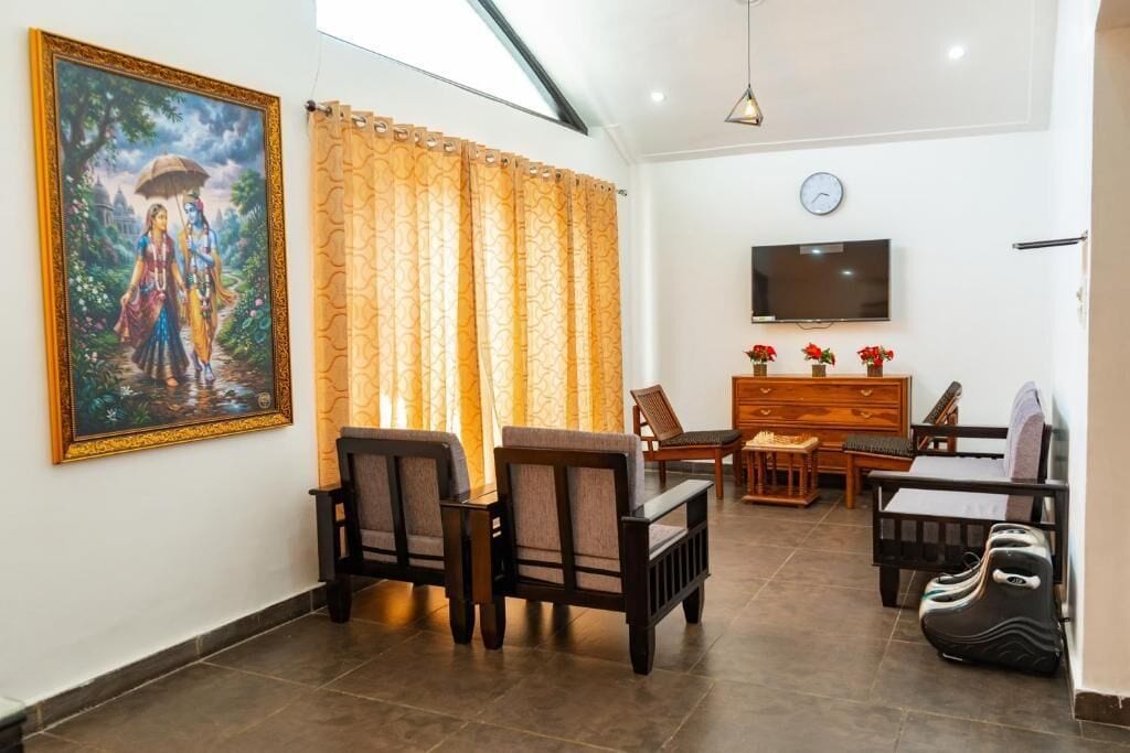 A living room with a TV, wooden furniture, a painting, and curtains.