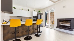 Una cucina moderna con tre sgabelli gialli, un forno integrato e un camino.