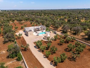 A modern villa with a swimming pool, surrounded by olive groves and a clear sky. - Trullo Elisa by Perle di Puglia (Carovigno)